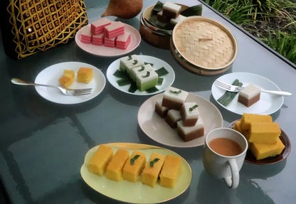 Assorted desserts on plates with a cup of tea on a reflective surface.