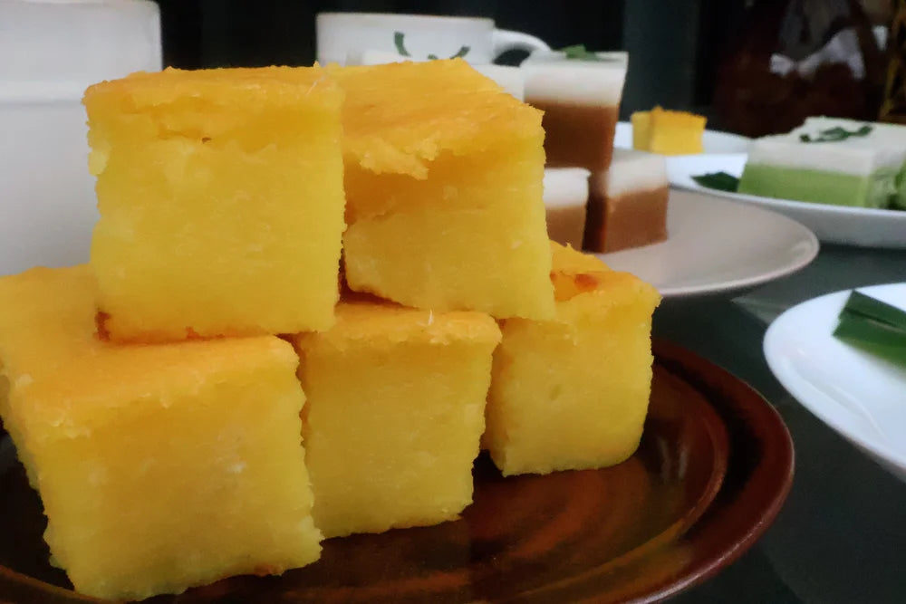Stack of yellow square pastries on a brown plate with a blurred background